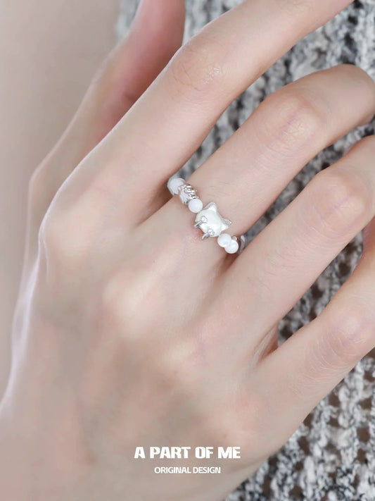 A PART OF ME shell cat beaded ring displayed on a hand, featuring elegant white beads and a cute shell cat design