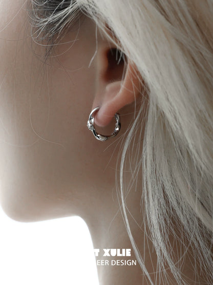 Shooting star silver earrings elegantly displayed on a model's ear with a soft hairstyle