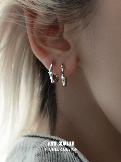 Shooting star silver earrings displayed on an ear with a modern design for stylish elegance