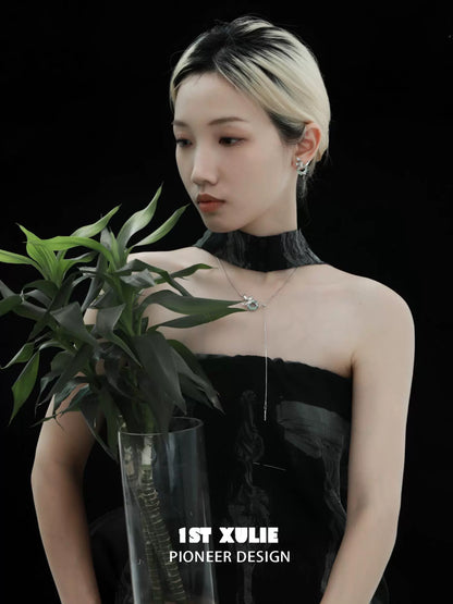 Silver iris pull buckle necklace displayed elegantly on a model with a plant backdrop