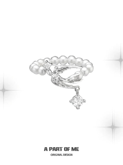 Unique silver pearl ring featuring a twisted design and a sparkling charm for elegant style