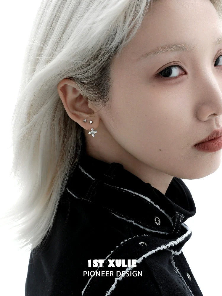 Stylish silver star earrings with sparkling details worn by model with short light hair