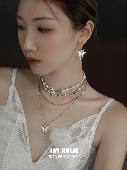 Elegant skeleton butterfly pearl necklace layered with matching earrings for a chic look