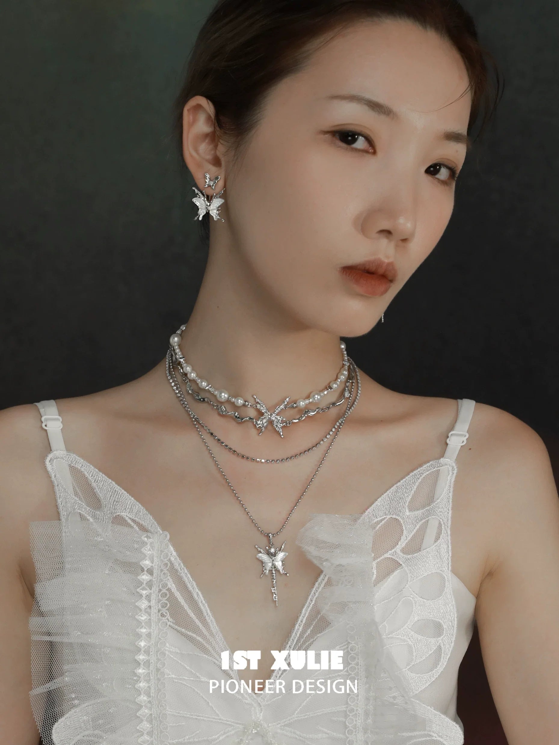 Layered skeleton butterfly pearl necklace with silver accents showcased on a model's neck