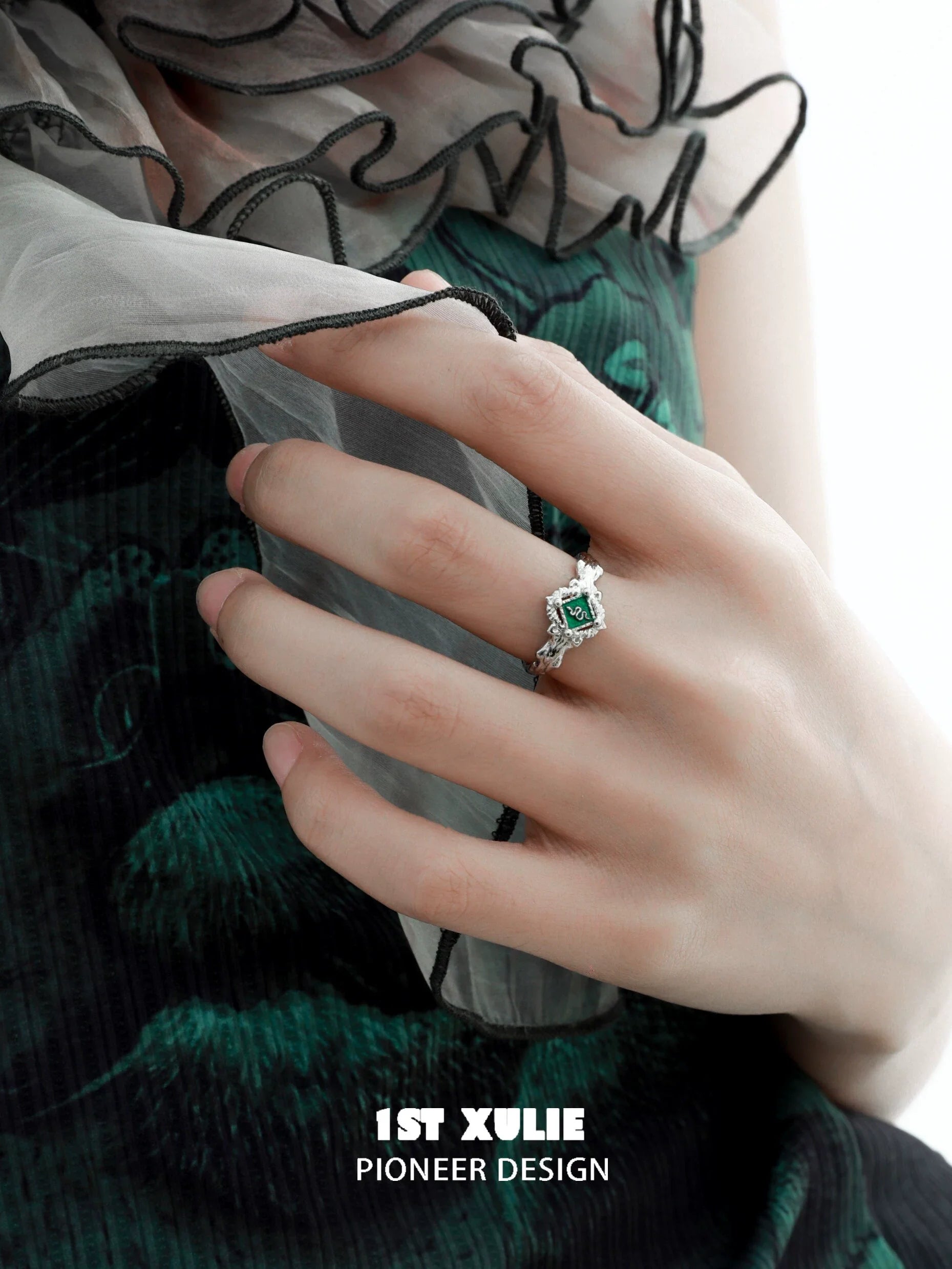 Slytherin green snake ring with intricate detailing set on a silver band, worn on a hand