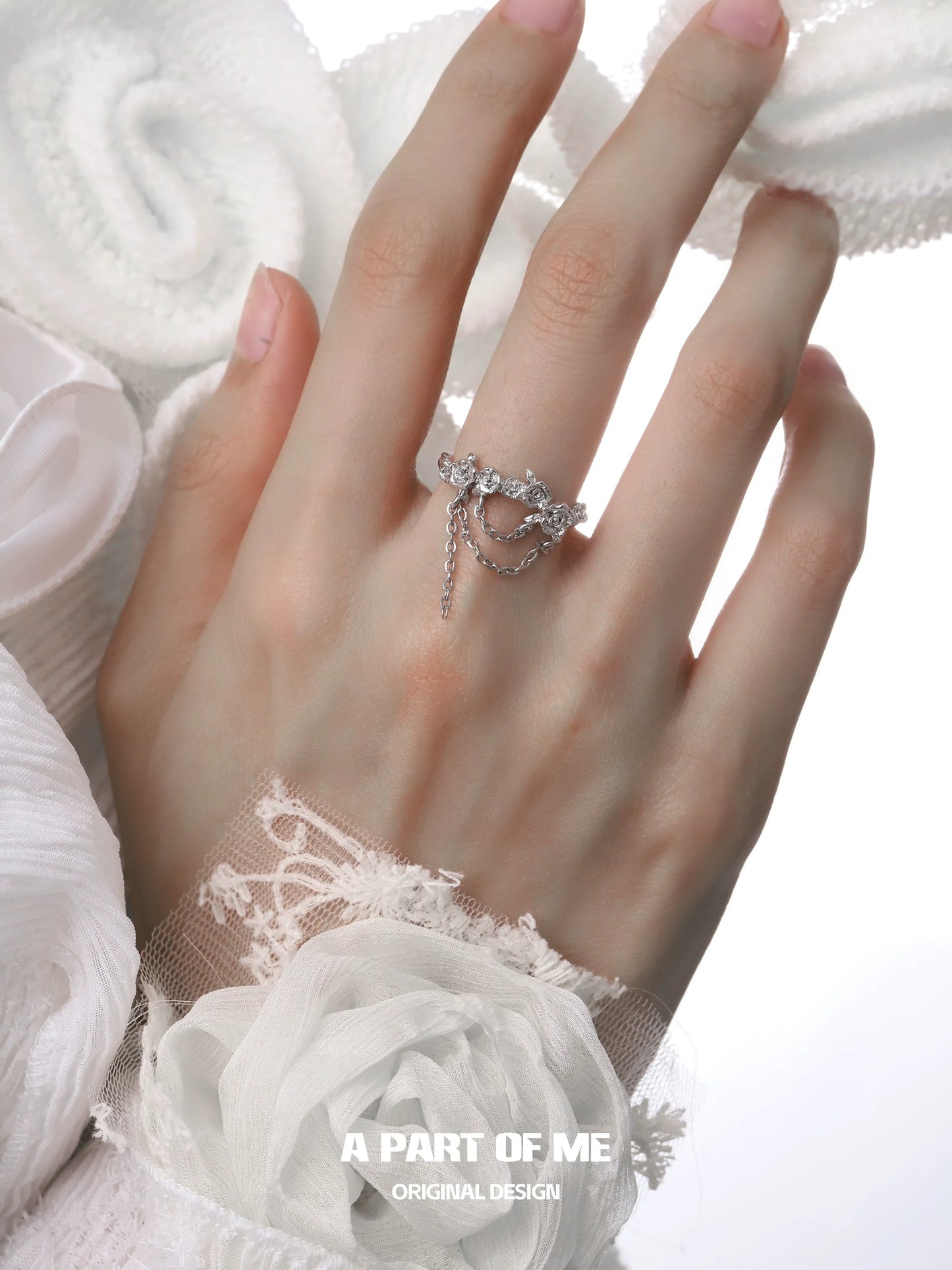 Elegant A PART OF ME snow rose chain ring worn on a hand with delicate lace and floral details