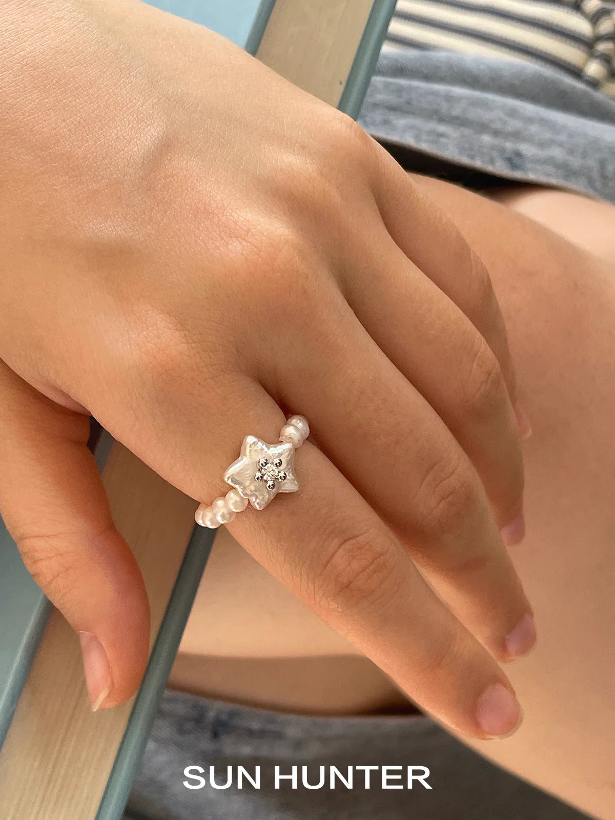 SUN HUNTER star pearl ring featuring a star design with a sparkling gem and pearl accents