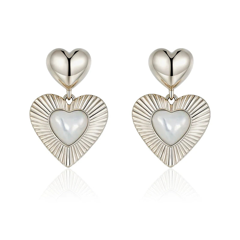 SUN HUNTER heart shaped statement earrings with polished silver and pearl details for a bold look