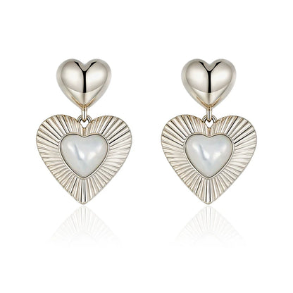 SUN HUNTER heart shaped statement earrings with polished silver and pearl details for a bold look