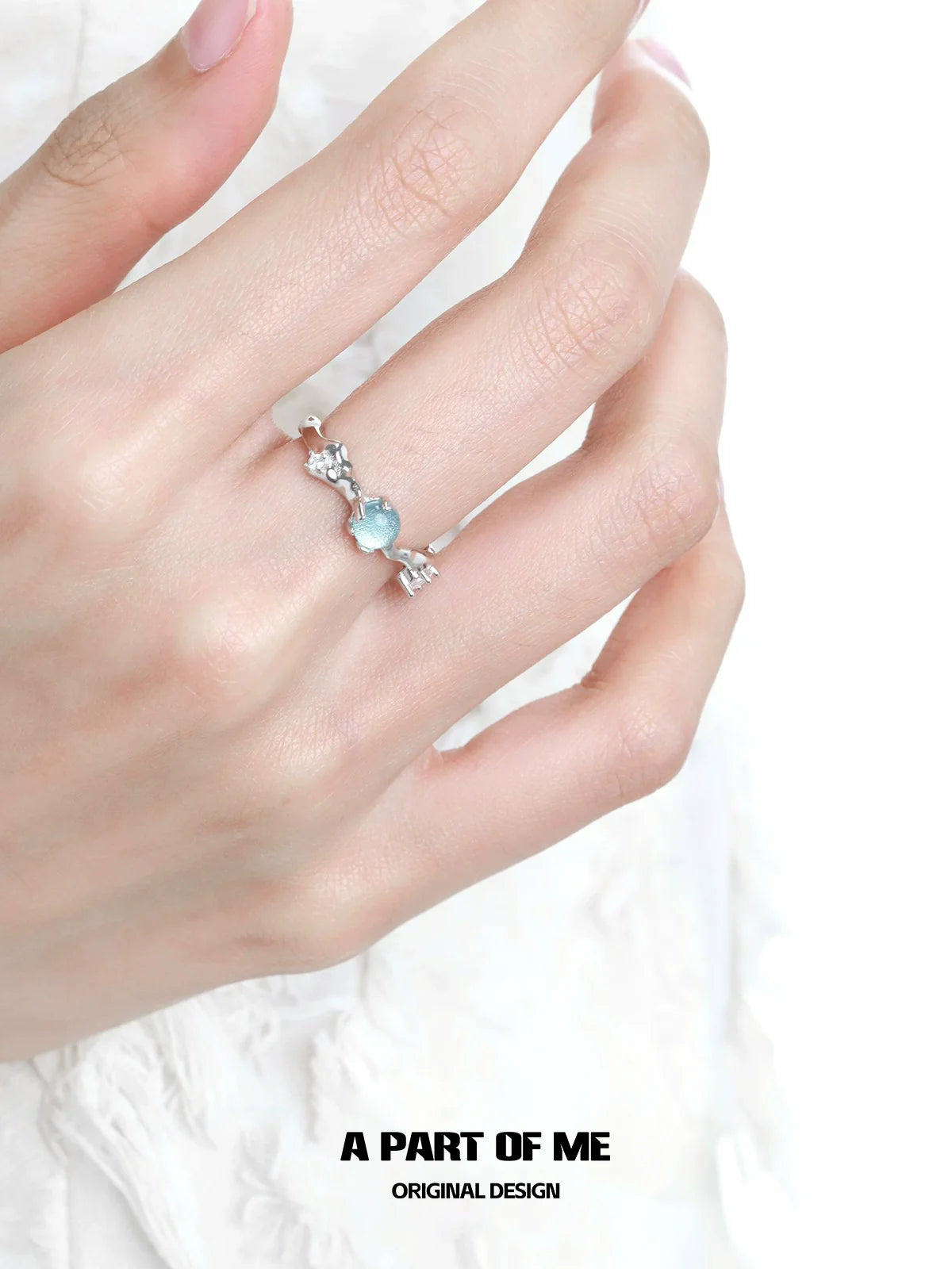 A Part of Me blue gemstone statement ring with intricate silver detailing on a model's hand