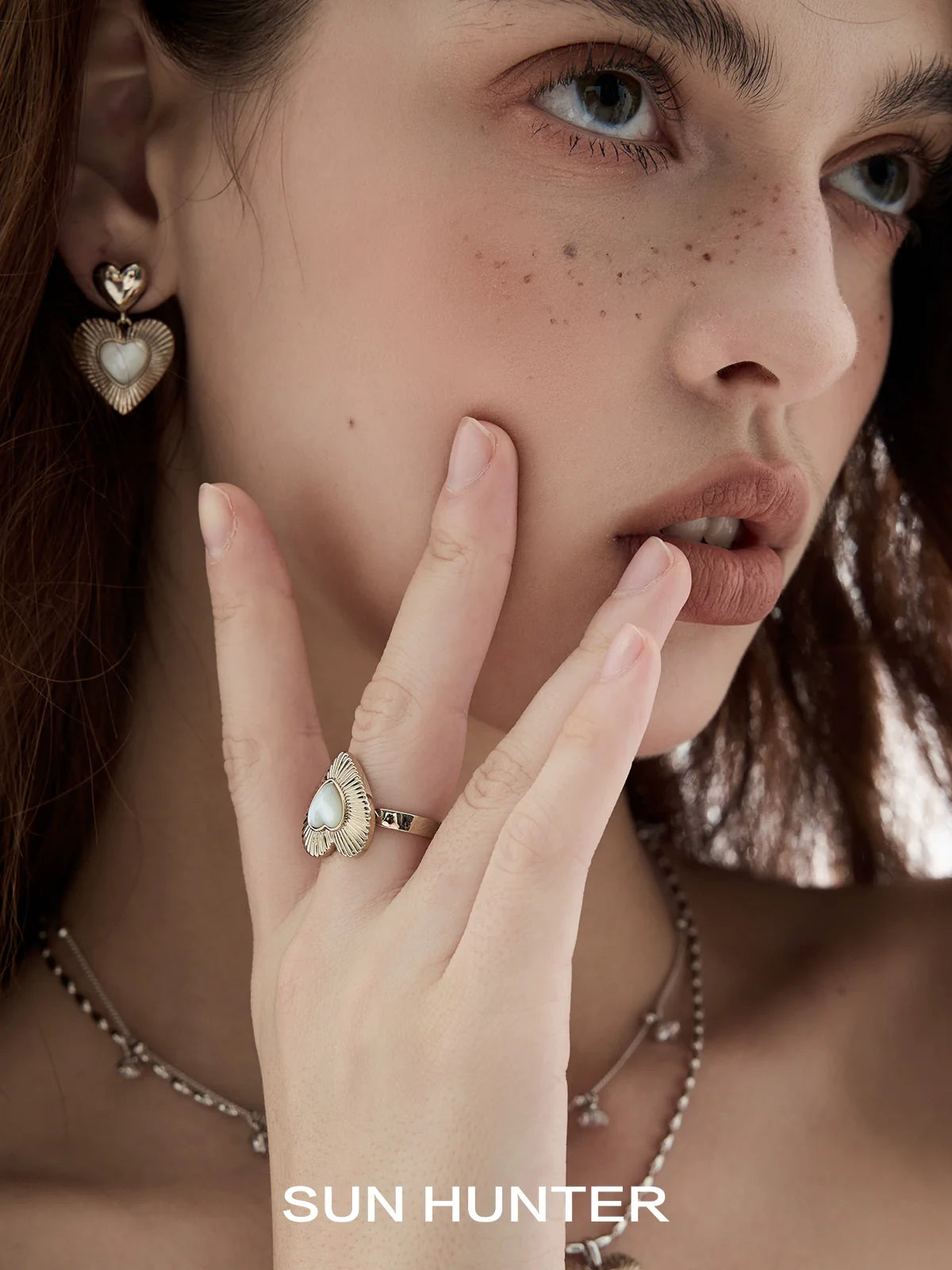 Elegant butterfly mother-of-pearl ring by SUN HUNTER, showcased on a model's hand with matching earrings