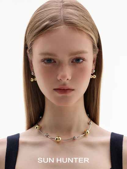 Model wearing SUN HUNTER jewelry planet silver necklace for women with gold and silver accents