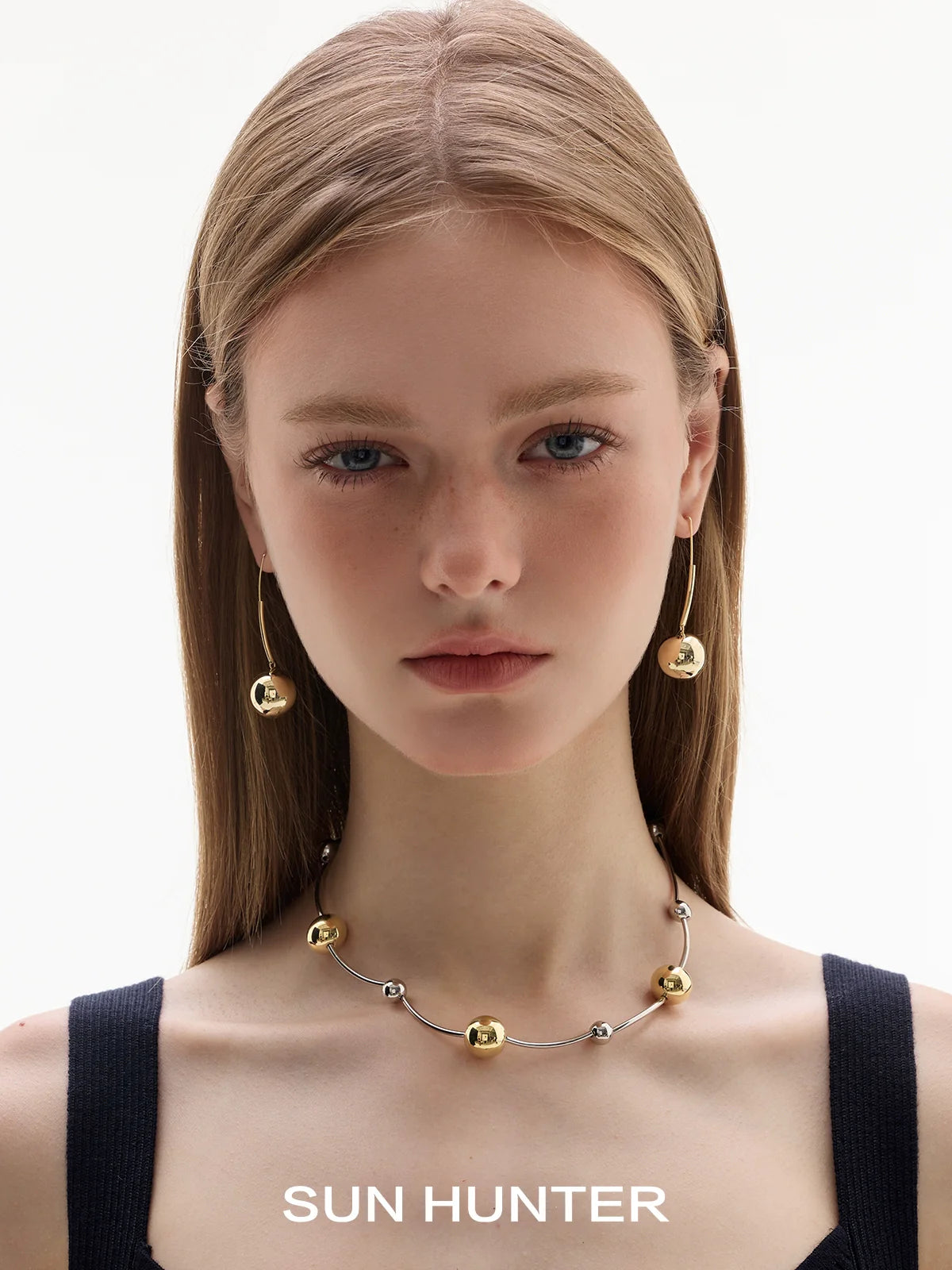 Model wearing sun hunter jewelry planet silver necklace for women with gold accent beads