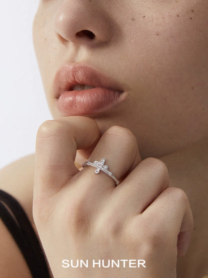 Elegant SUN HUNTER lace cross ring worn on a model's finger with a close-up view