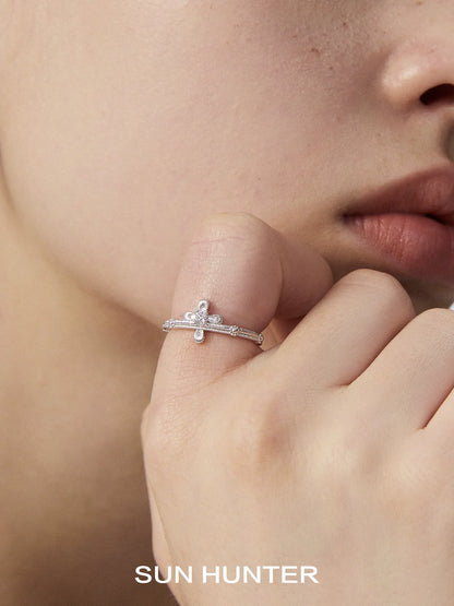 SUN HUNTER lace cross ring in sterling silver worn on a model's finger close to the face