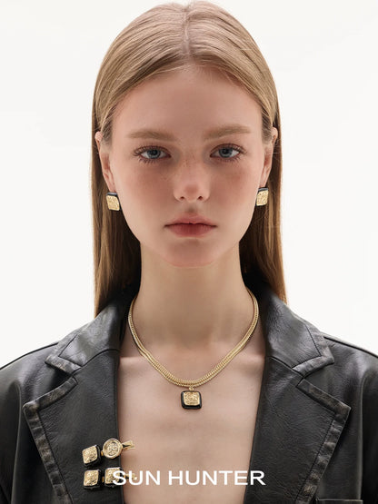 Model wearing SUN HUNTER vintage coin stud earrings with gold chains for a chic look