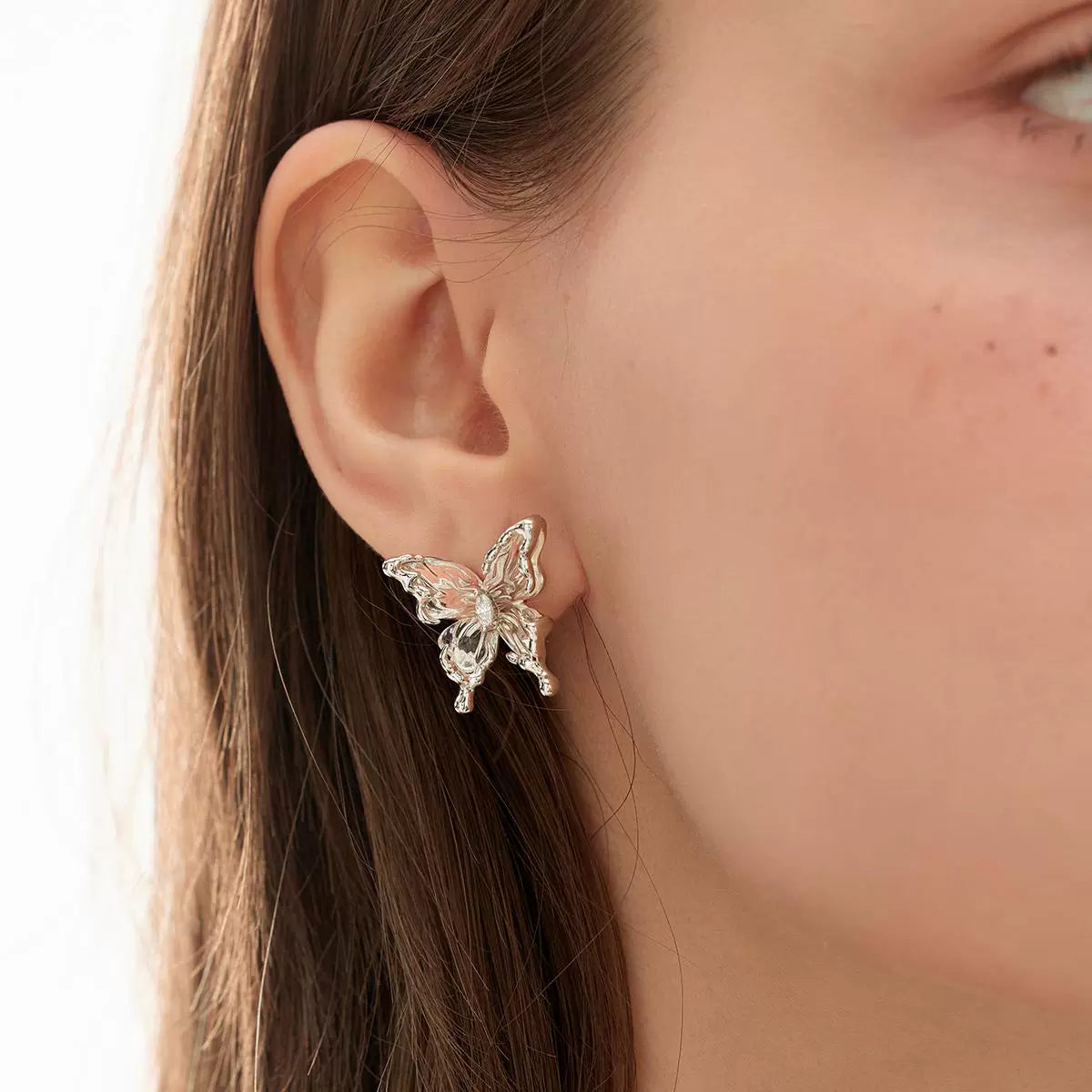 Elegant transparent butterfly earrings by SUN HUNTER, showcasing a delicate design for a refined look