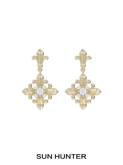 Unique floral drop earrings by SUN HUNTER featuring an elegant gold design with a sparkling center stone