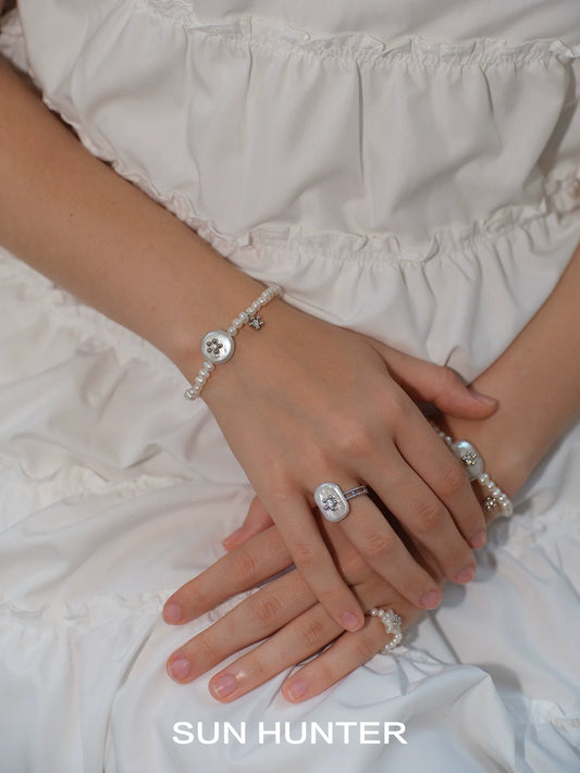 SUN HUNTER unique pearl bracelet paired with matching jewelry, elegantly worn on a model's hands