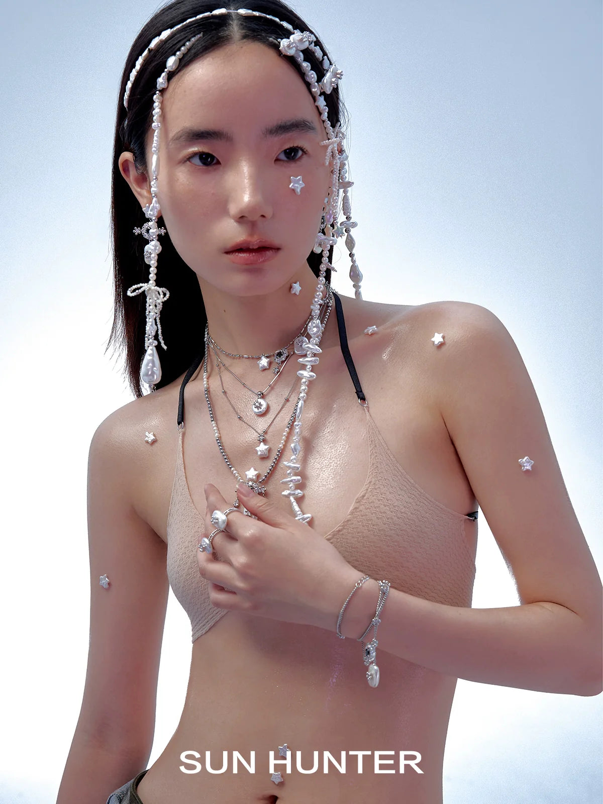 Model wearing a unique pearl bracelet with multiple strands of pearls and decorative accents