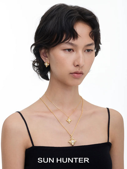 Model wearing unique square stud earrings by SUN HUNTER paired with a matching necklace