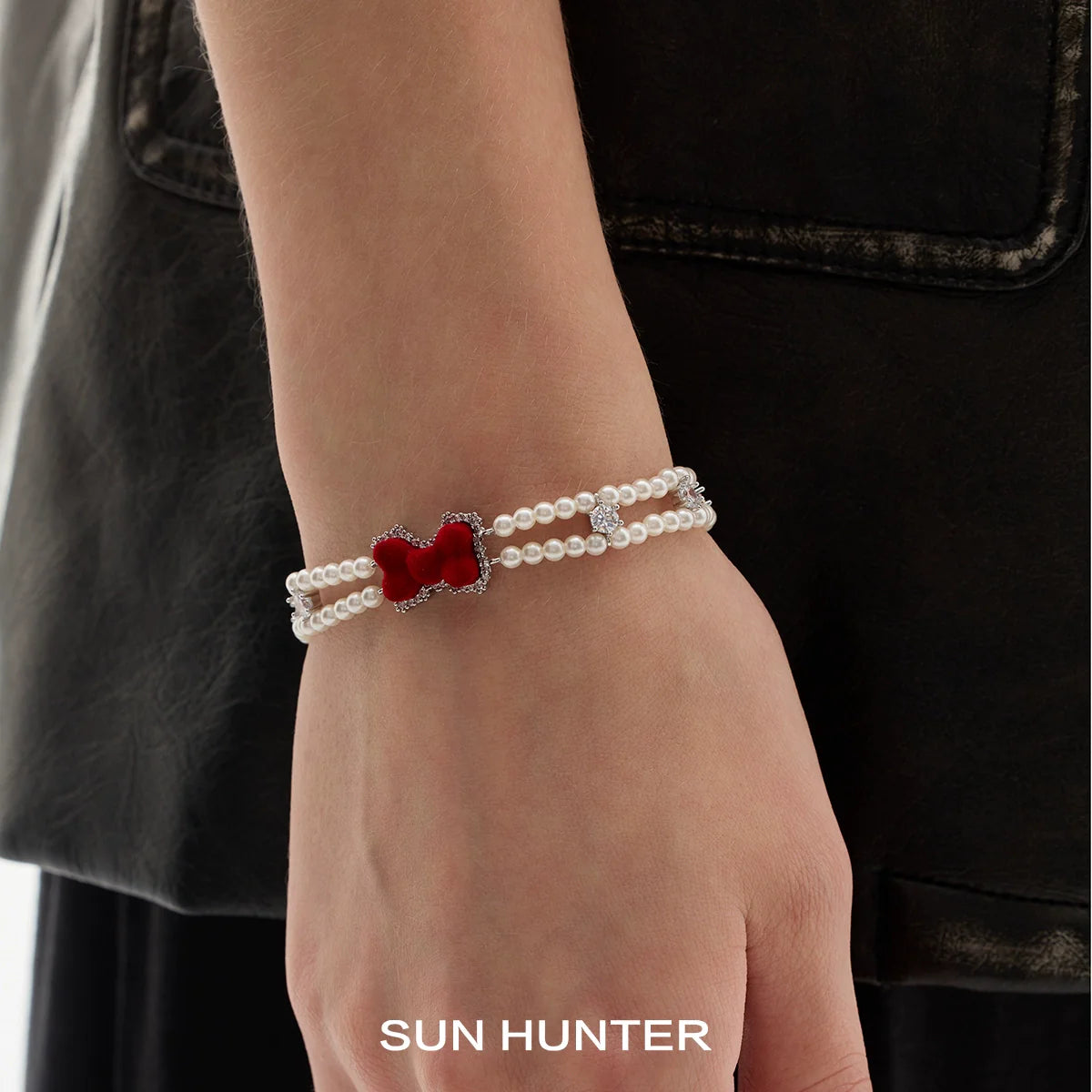 Elegant velvet bow pearl bracelet by SUN HUNTER featuring a red bow charm and pearl detailing