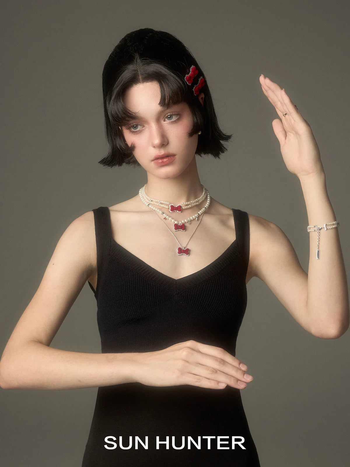 Elegant velvet bow pearl bracelet by SUN HUNTER, featuring delicate pearls and a stylish bow design.