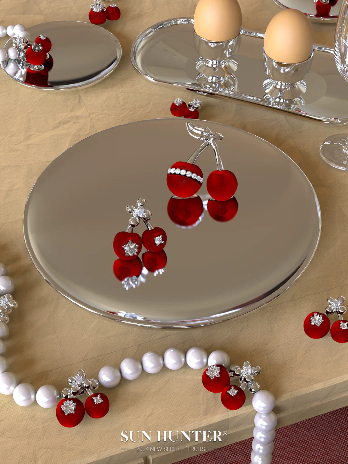 SUN HUNTER velvet cherry pearl bracelet showcased on a reflective plate with decorative cherries and eggs