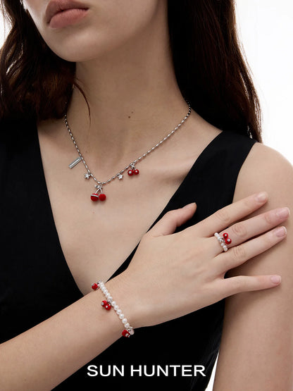 SUN HUNTER velvet cherry pearl ring displayed on a model's hand with matching jewelry