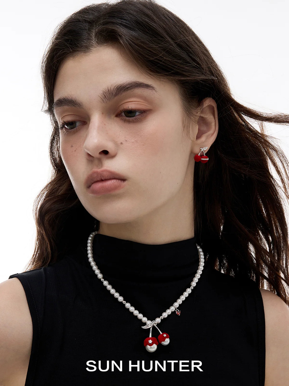 Model wearing velvet cherry stud earrings by SUN HUNTER with a pearl necklace for a stylish look