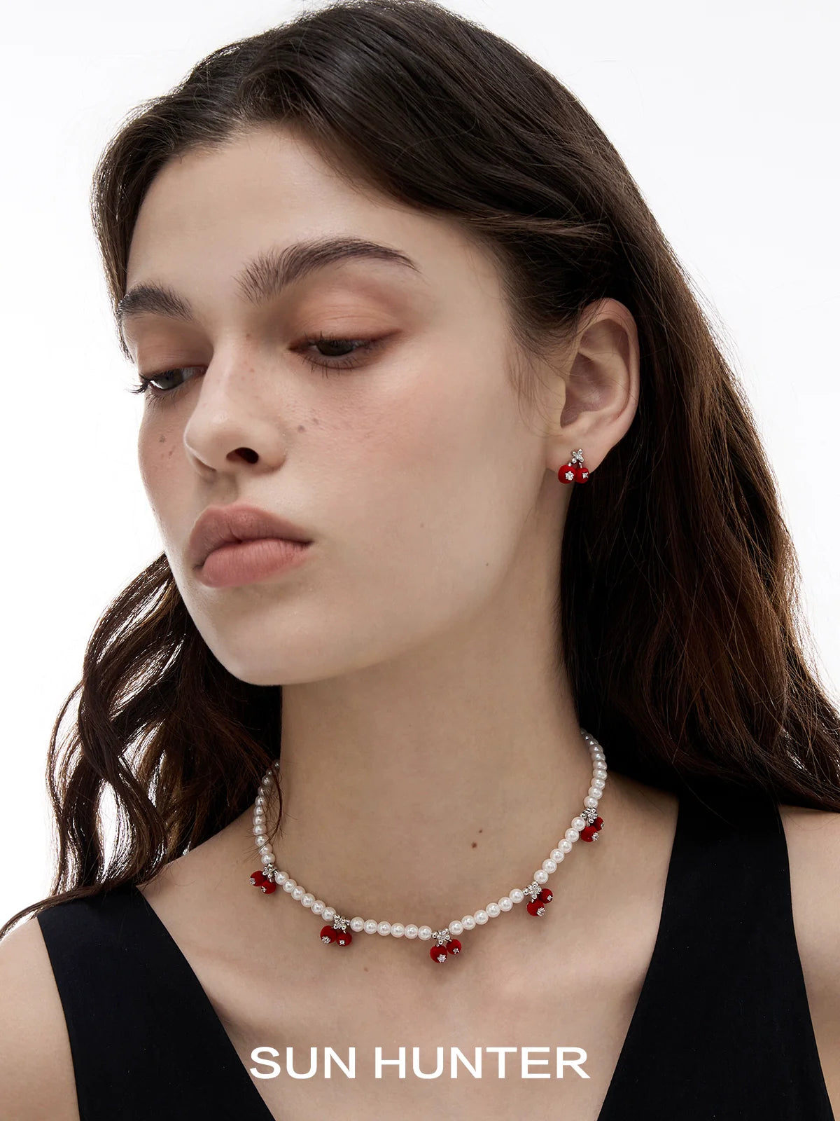 Model wearing velvet cherry stud earrings paired with a matching necklace for a stylish look