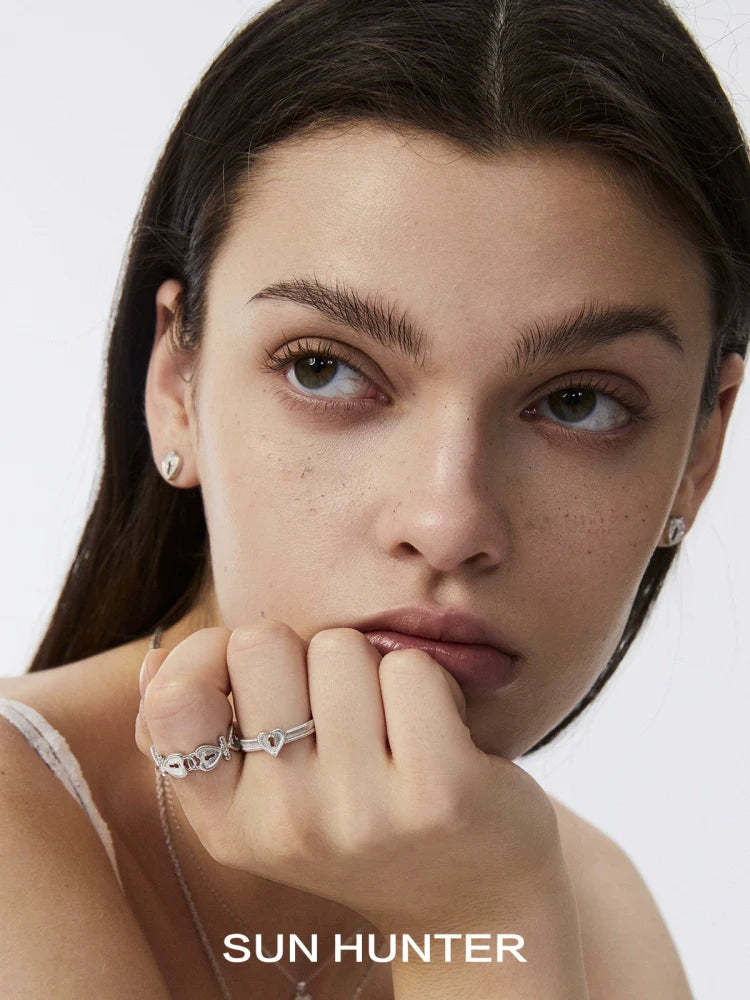Model wearing a silver love lock chain ring and matching jewelry from SUN HUNTER