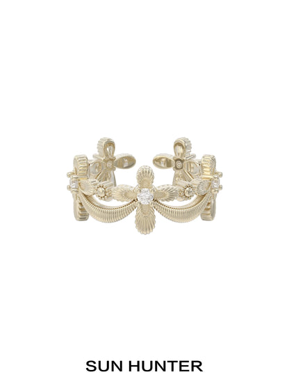 Elegant SUN HUNTER shimmer cross ring featuring intricate detailing and a sparkling center stone