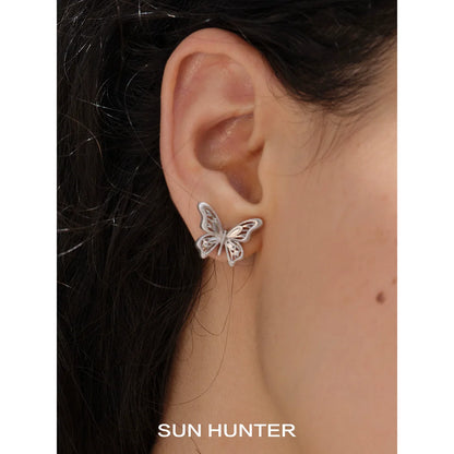 Vintage butterfly earrings displayed on a model's ear, showcasing an elegant design by SUN HUNTER