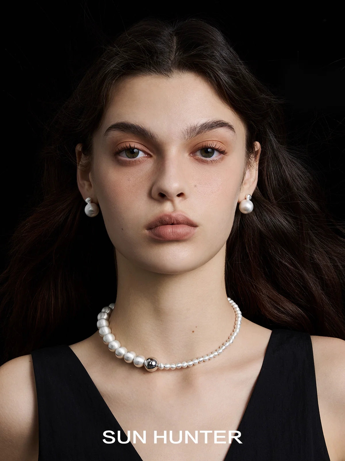 Elegant vintage cocoon earrings paired with a sophisticated pearl necklace by SUN HUNTER