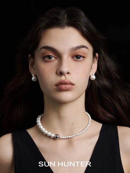 Elegant vintage cocoon earrings paired with a sophisticated pearl necklace by SUN HUNTER