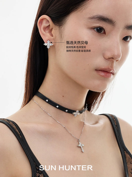 Stylish model wearing vintage cross earrings paired with layered necklaces for a trendy look