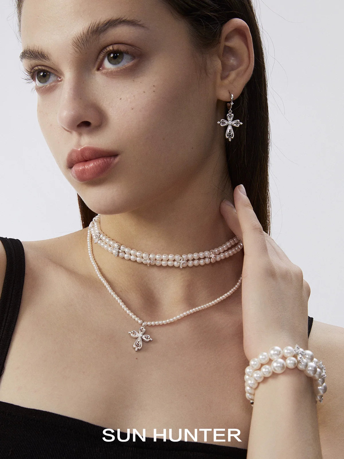 Elegant vintage cross earrings from SUN HUNTER paired with pearl jewelry for a classic look