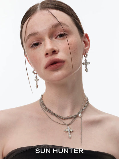 Model wearing SUN HUNTER vintage cross earrings with a stylish layered necklace for a chic look