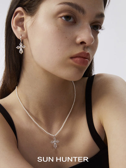 Elegant vintage cross pearl necklace from SUN HUNTER worn with matching earrings for a classic look
