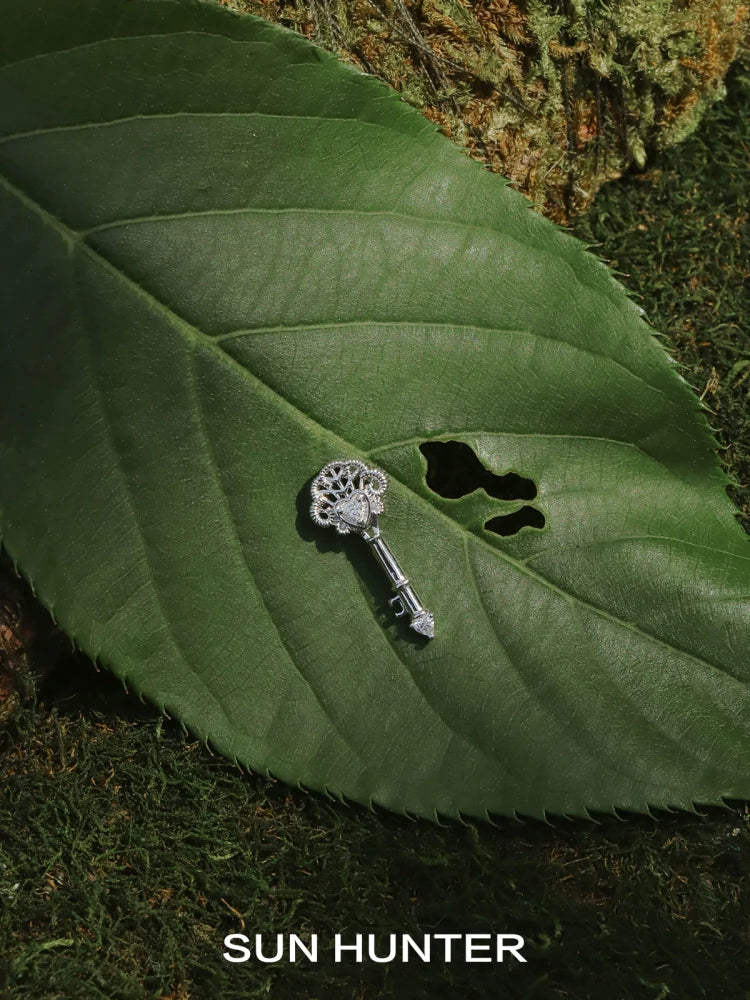 SUN HUNTER vintage lace key earrings displayed on a green leaf for a natural look