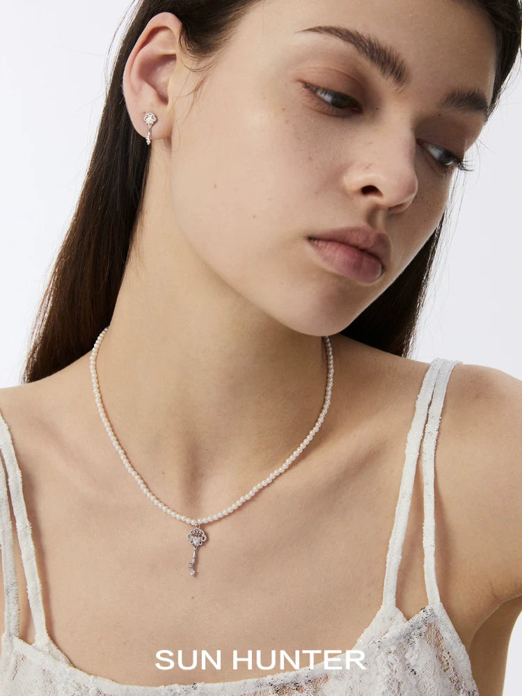 Elegant model showcasing vintage lace key earrings paired with a delicate necklace from SUN HUNTER