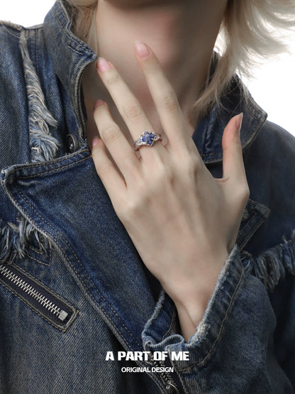 Violet gemstone ring showcased on a hand wearing a denim jacket with a stylish design