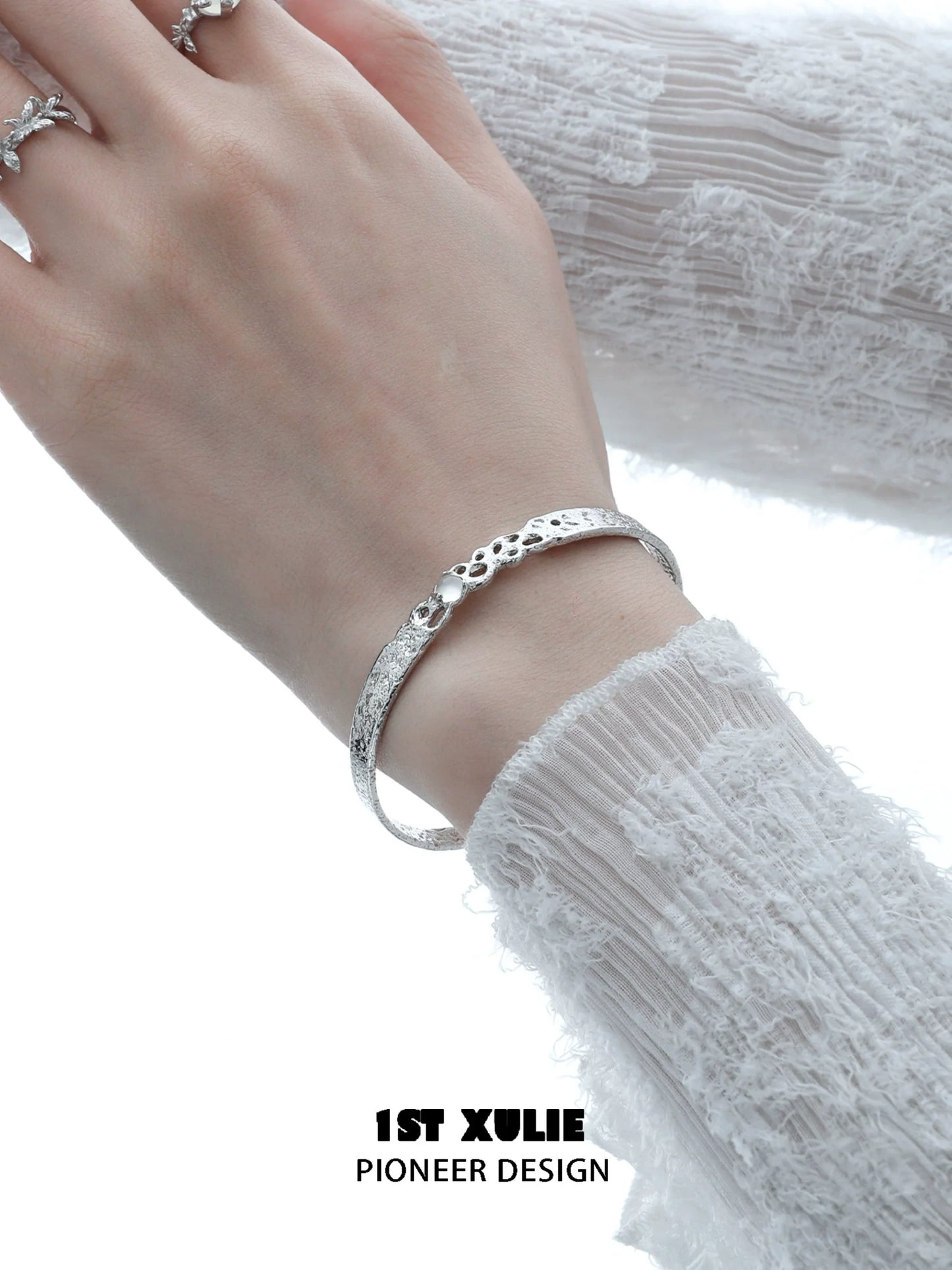 Elegant white agate bangle bracelet on a woman's wrist, featuring a textured design
