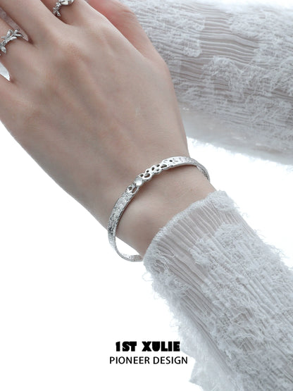 Elegant white agate bangle bracelet on a woman's wrist, featuring a textured design