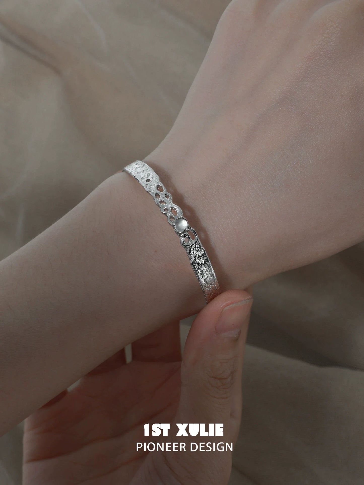 Elegant white agate bangle bracelet displayed on a hand, showcasing its intricate design
