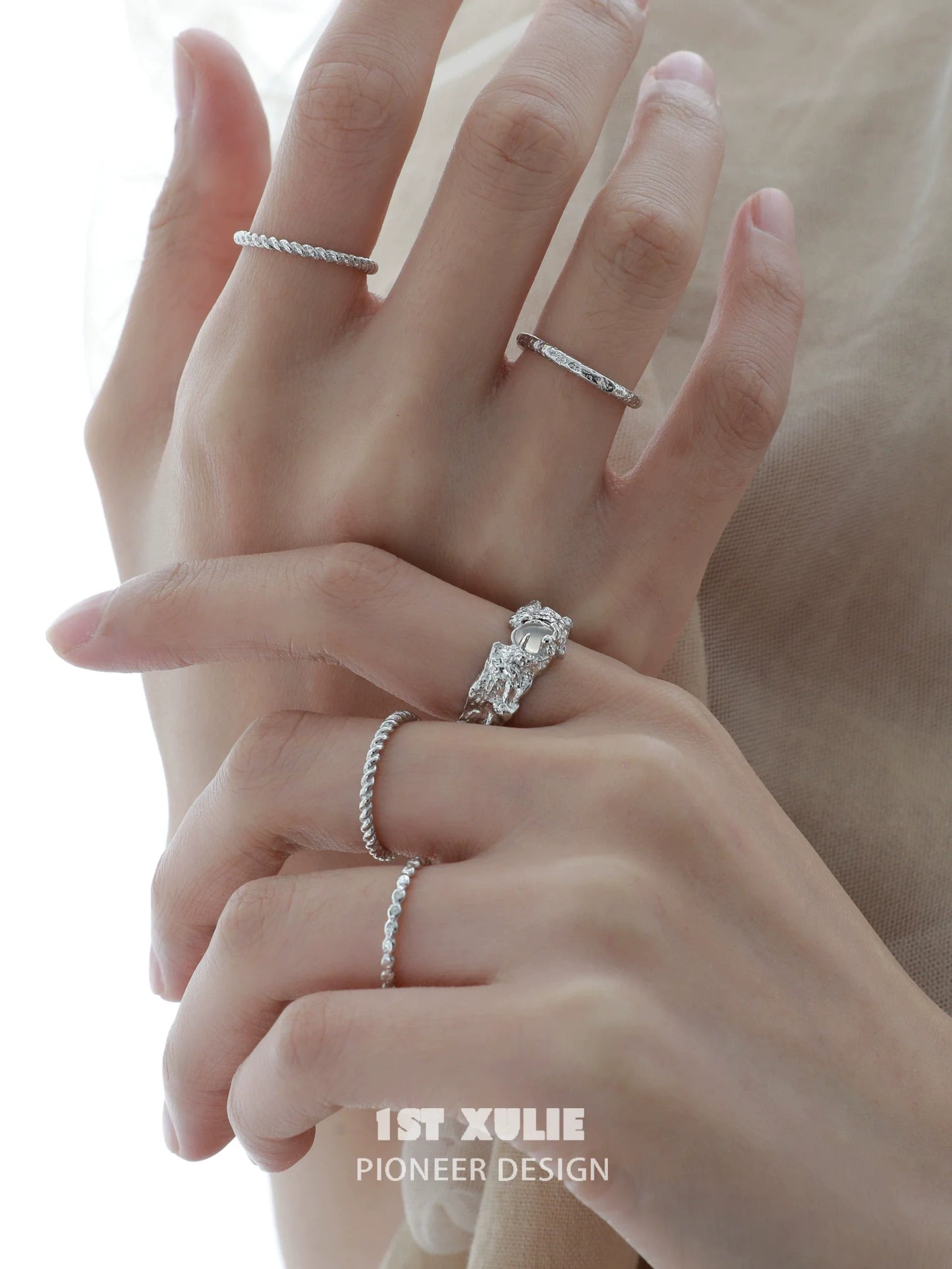 Elegant white agate ring showcased alongside other delicate silver rings on a hand