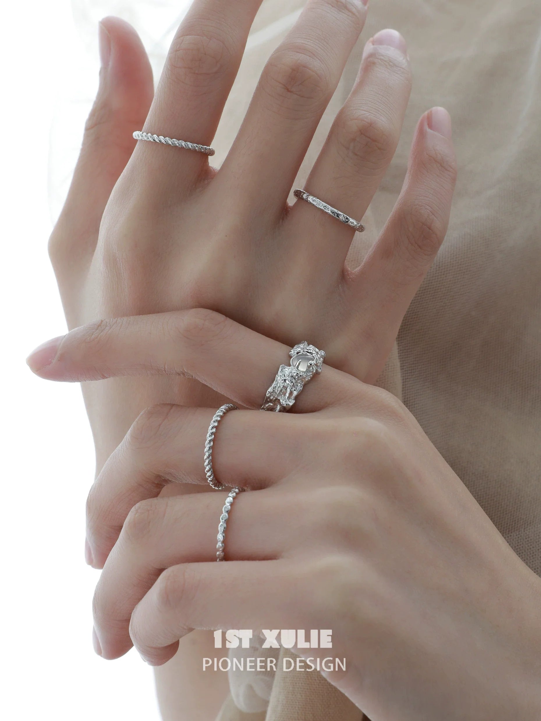 Elegant white agate ring showcased alongside other delicate silver rings on a hand