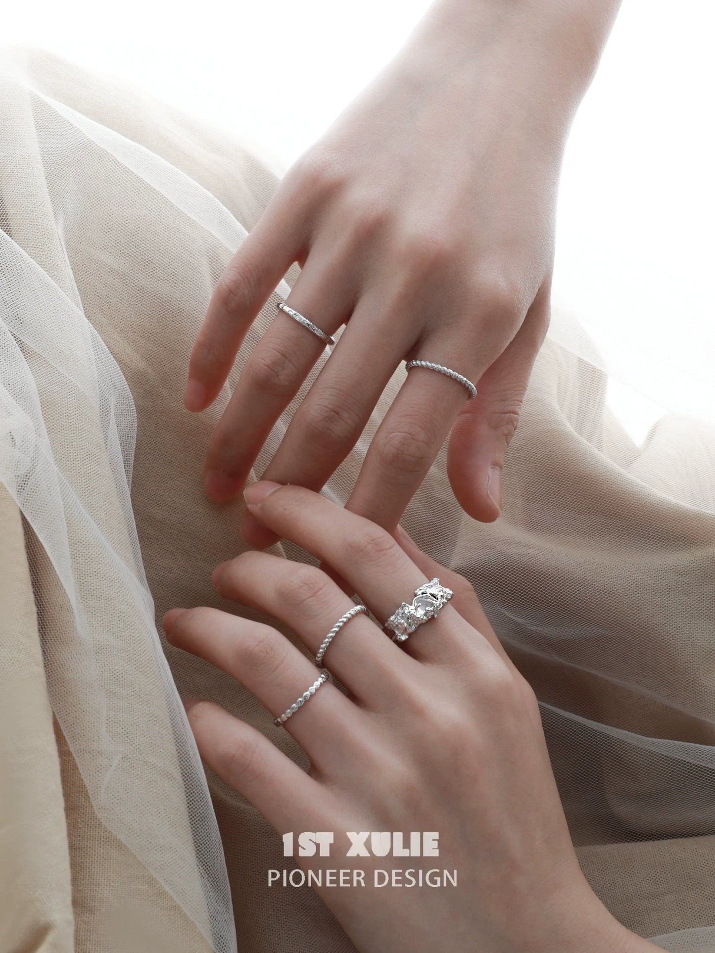 Elegant white agate ring displayed with silver stacking rings on a woman's hands