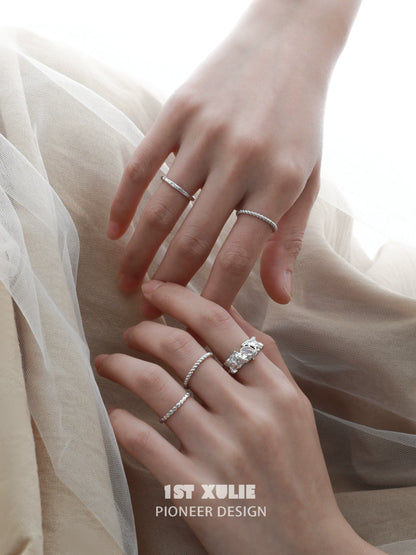 Elegant white agate ring displayed with silver stacking rings on a woman's hands